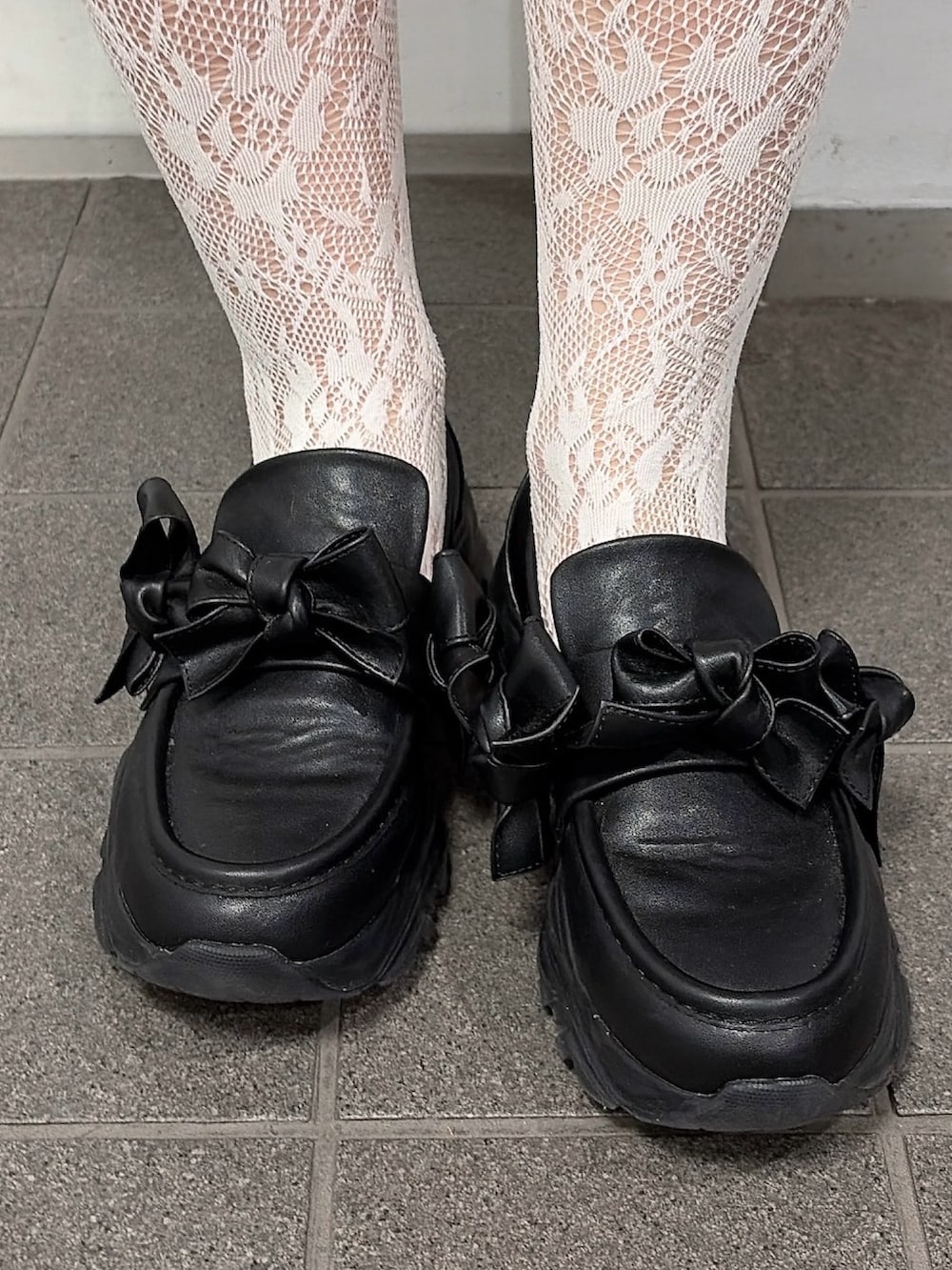 ブルー系のワンピース、ベージュ系のメッセンジャーバッグ、ブラック系のスニーカーを着用したレディースの冬コーディネートの7枚目の写真