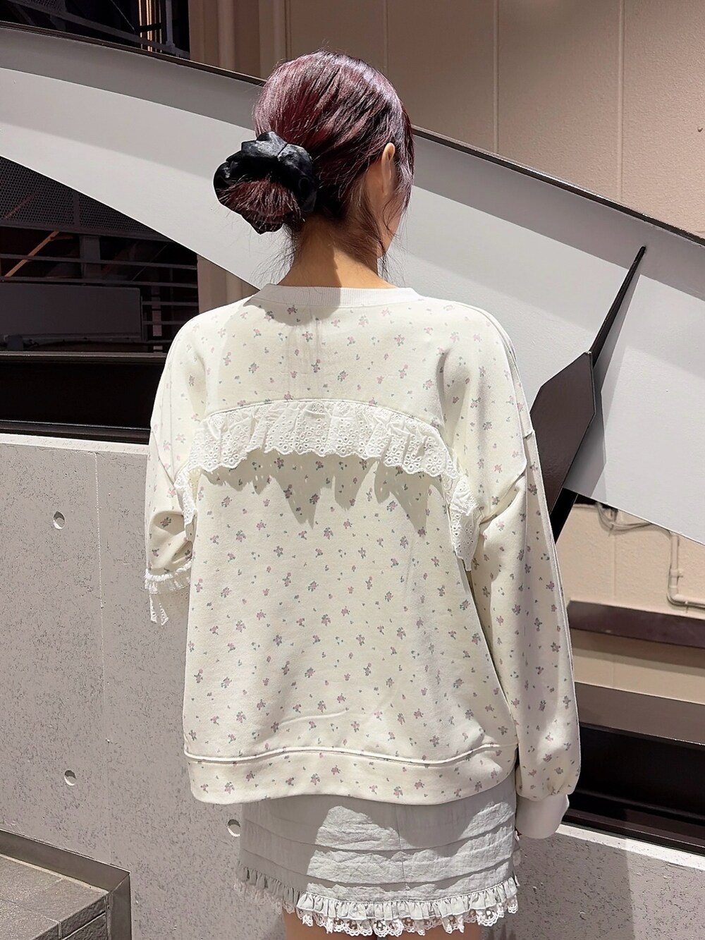 ホワイト系のスウェット、ブルー系のスカート、ブラック系のスニーカーを着用したレディースの冬コーディネートの4枚目の写真