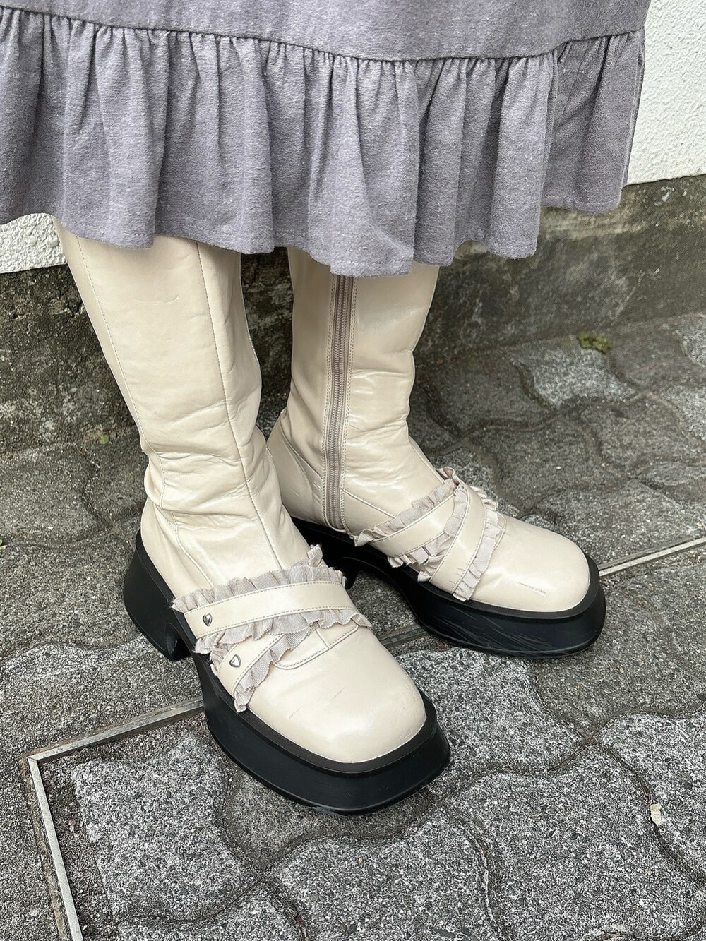 ブラック系のブルゾン、グレー系のワンピース、ホワイト系のブーツを着用したレディースの冬コーディネートの4枚目の写真