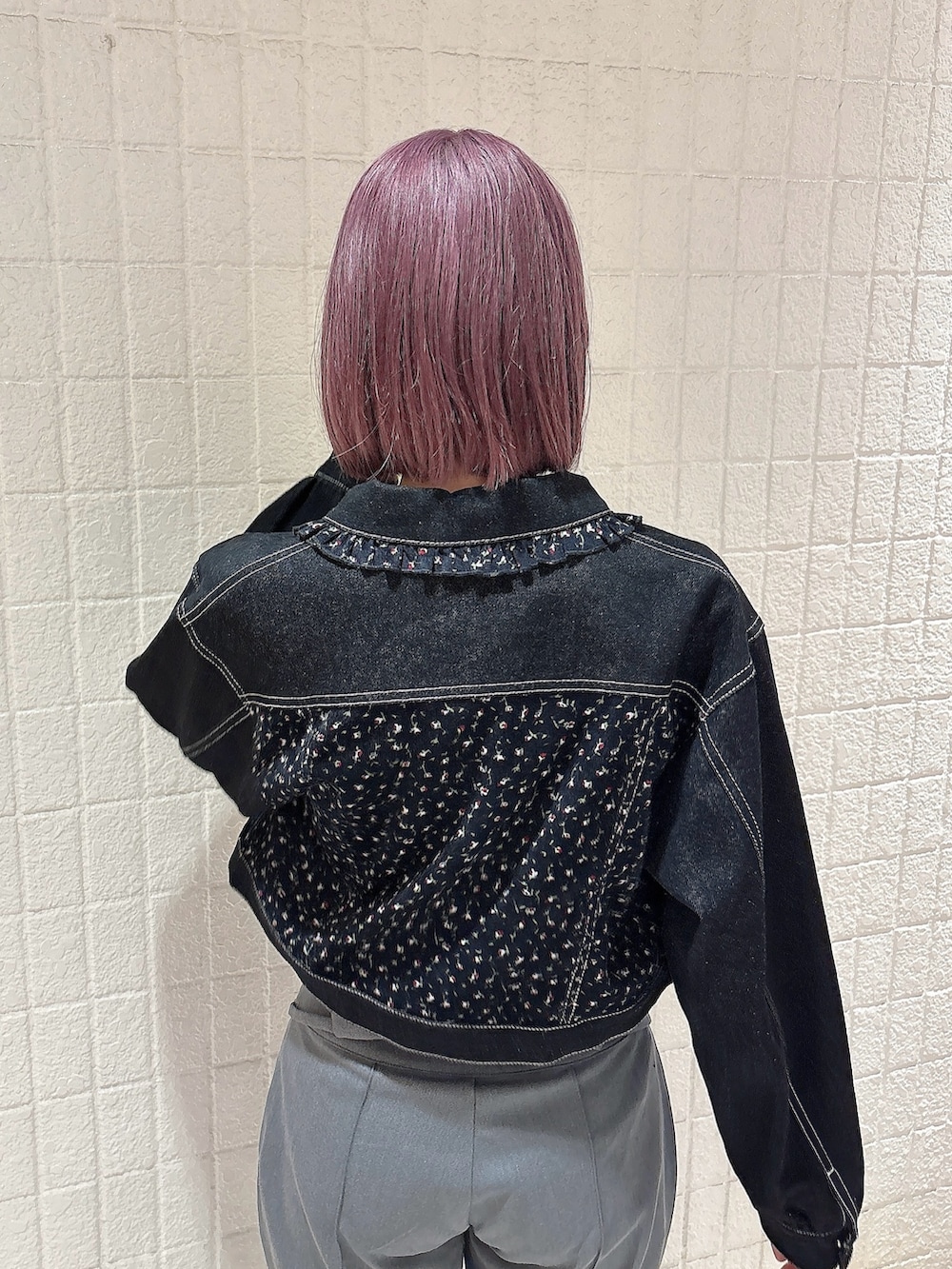 グレー系のスラックス、ブラック系のバレエシューズ、ブラック系のデニムジャケットを着用したレディースの春コーディネートの4枚目の写真