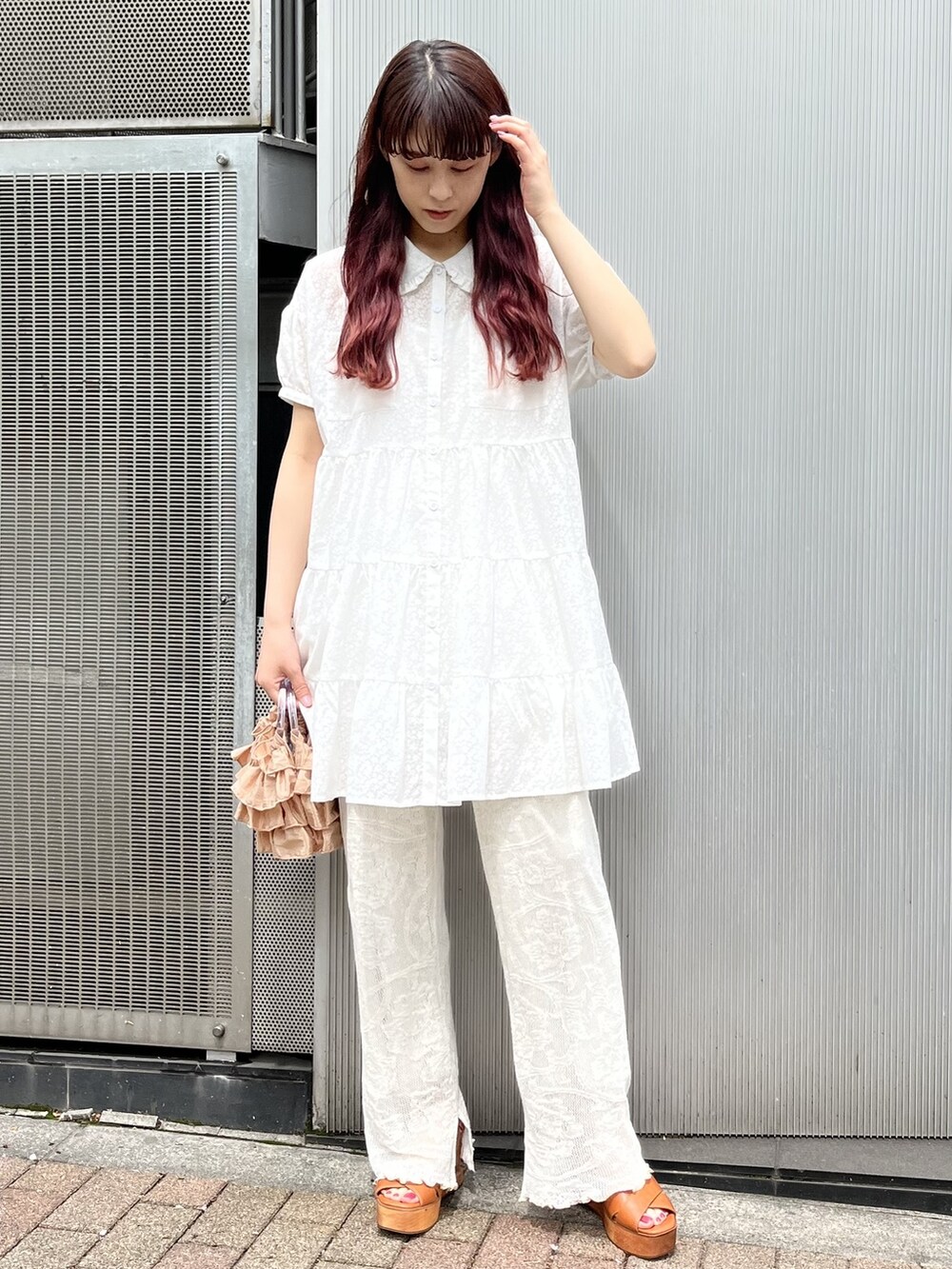 ホワイト系のその他パンツ、オレンジ系のハンドバッグ、ブラウン系のサンダルを着用したレディースの春コーディネートの2枚目の写真