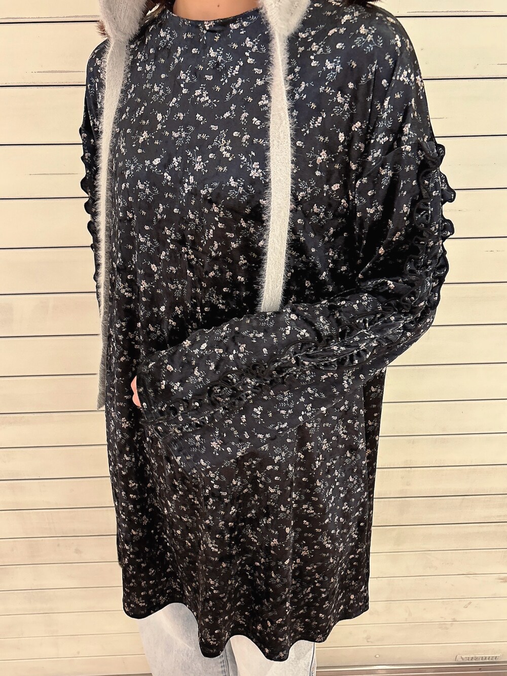 ブラック系のワンピース、ブルー系のデニムパンツ、ブラック系のスニーカーを着用したレディースの秋コーディネートの5枚目の写真