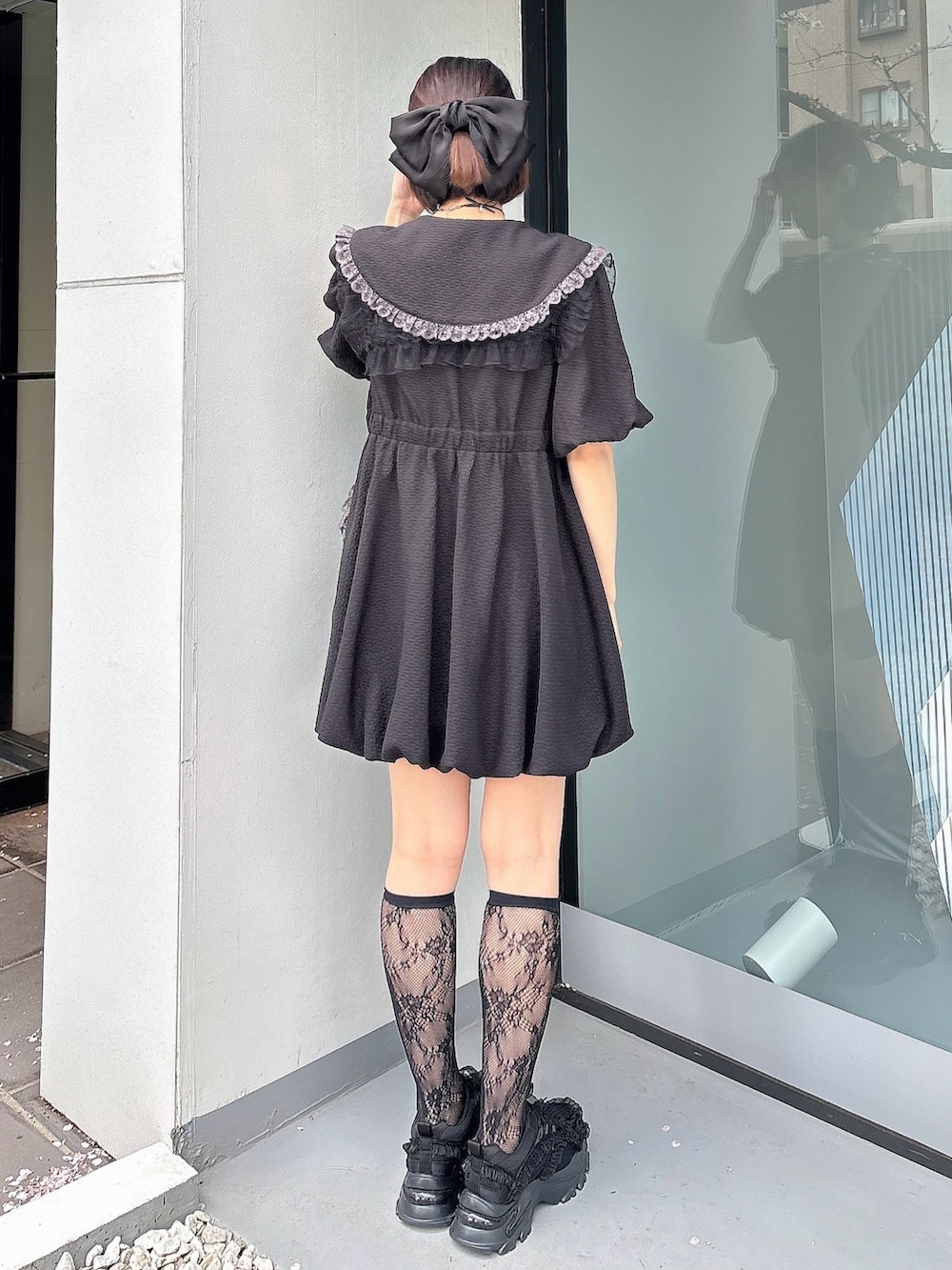 ブラック系のワンピース、ブラック系のスニーカー、ブラック系の付け襟を着用したレディースの春コーディネートの2枚目の写真