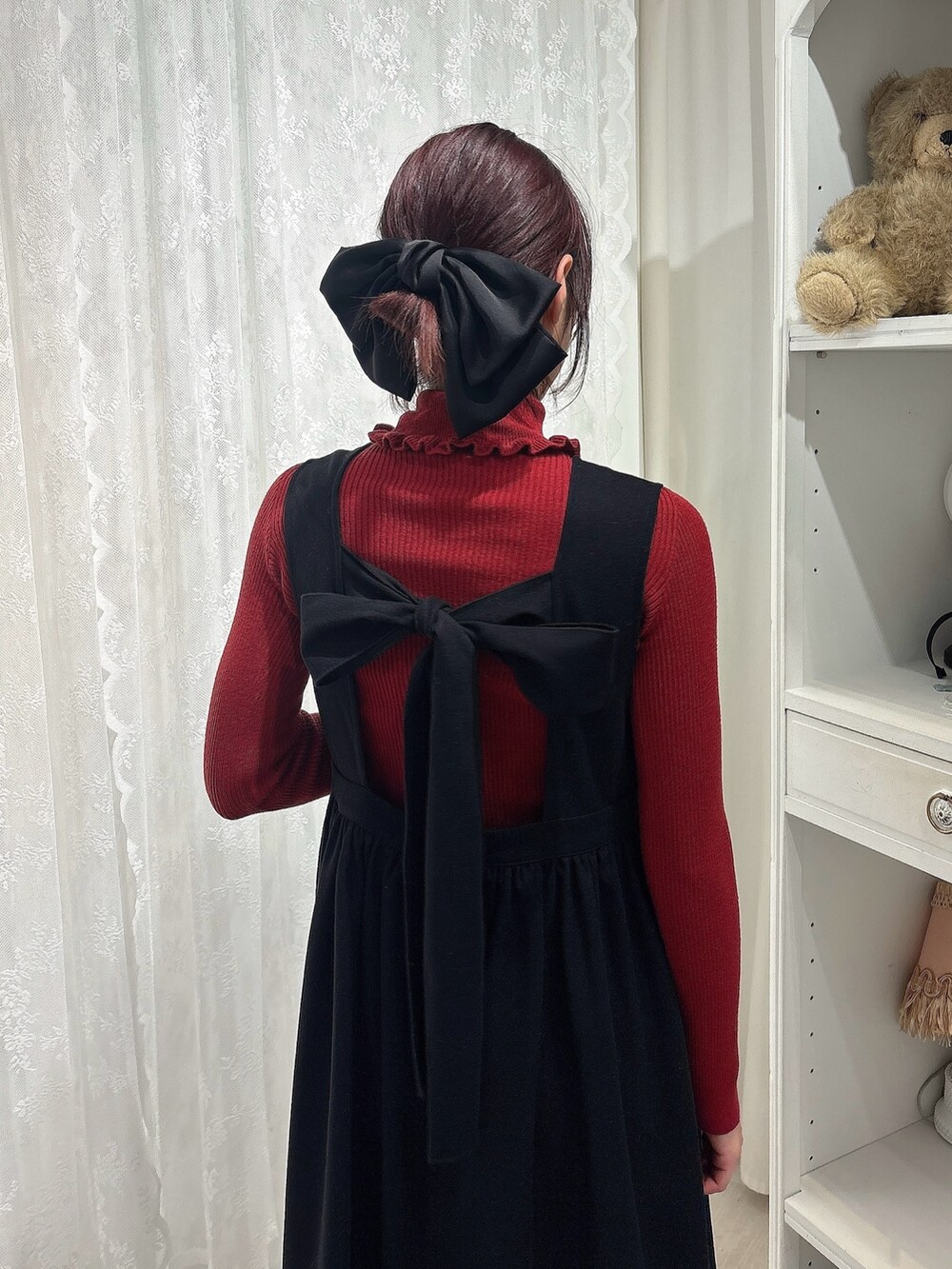レッド系のニット/セーター、ベージュ系のショルダーバッグ、ブラック系のワンピースを着用したレディースの秋コーディネートの4枚目の写真