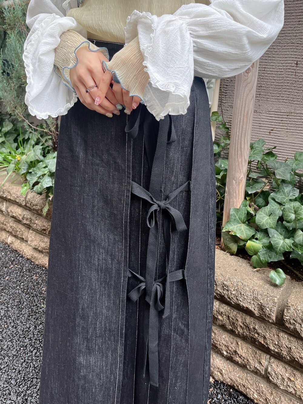 ブラック系のサンダル、ブラック系のデニムスカート、ホワイト系のシャツ/ブラウスを着用したレディースの春コーディネートの3枚目の写真