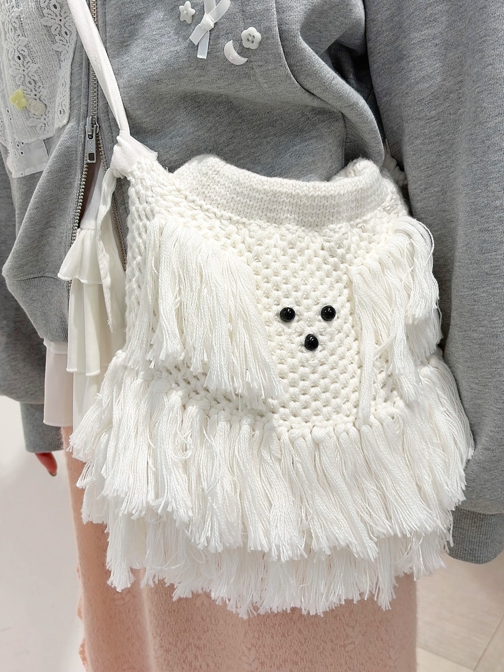 グレー系のパーカー、ホワイト系のショルダーバッグ、ホワイト系のTシャツ/カットソーを着用したレディースの秋コーディネートの7枚目の写真
