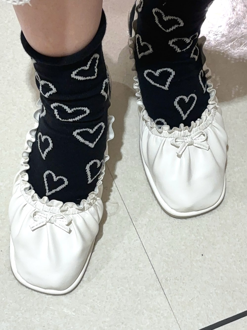 ホワイト系のワンピース、ホワイト系のカーディガン/ボレロ、ブラック系のTシャツ/カットソーを着用したレディースの春コーディネートの7枚目の写真