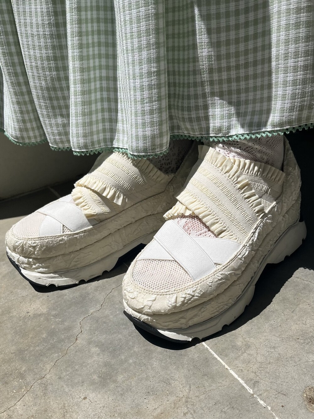 グリーン系のスカート、ホワイト系のスニーカー、ホワイト系のTシャツ/カットソーを着用したレディースの夏コーディネートの5枚目の写真