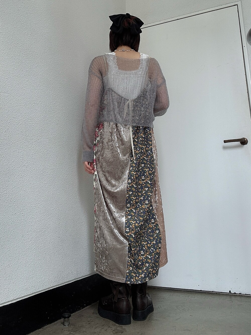 グレー系のニット/セーター、ピンク系のワンピース、ブラウン系のブーツを着用したレディースの夏コーディネートの2枚目の写真