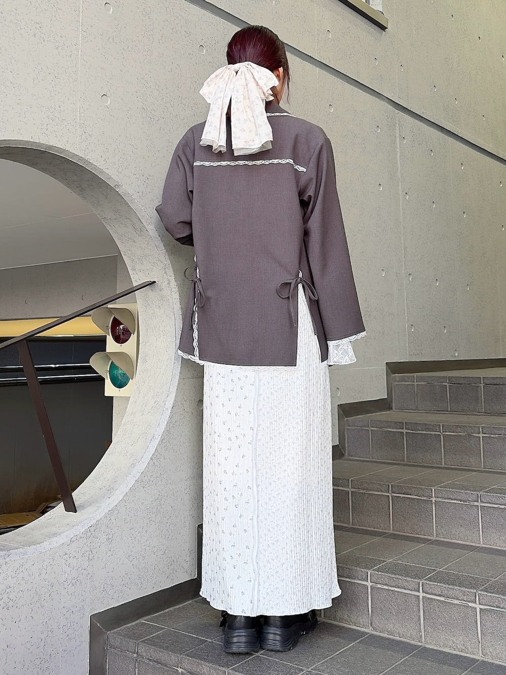 グレー系のテーラードジャケット、グレー系のTシャツ/カットソー、パープル系のスカートを着用したレディースの冬コーディネートの2枚目の写真