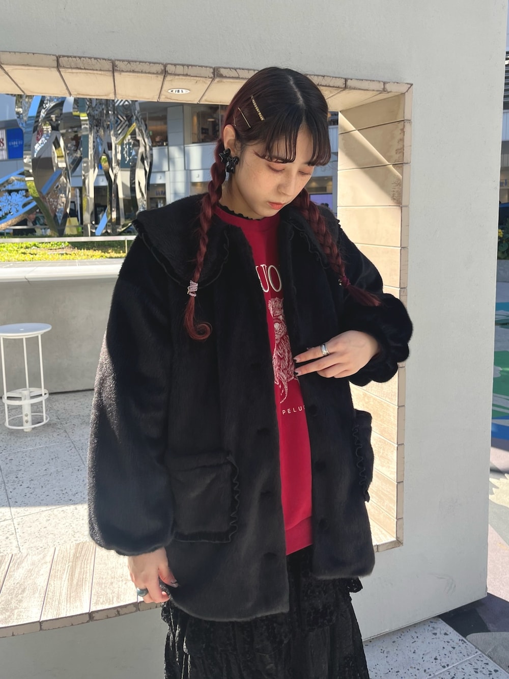 ベージュ系のブーツ、レッド系のスウェット、ブラック系のスカートを着用したレディースの冬コーディネートの2枚目の写真