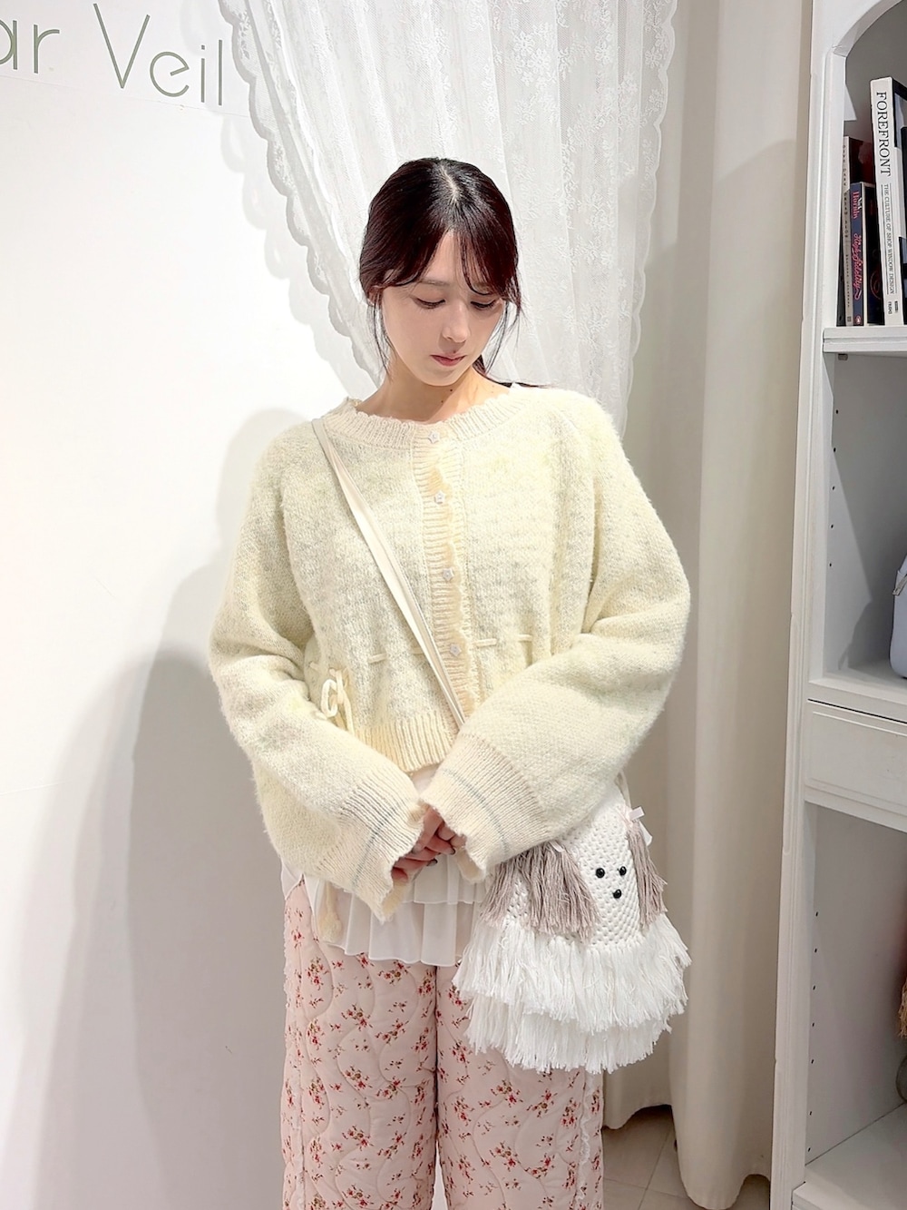 ホワイト系のカーディガン/ボレロ、ホワイト系のTシャツ/カットソー、ベージュ系のショルダーバッグを着用したレディースの秋コーディネートの4枚目の写真