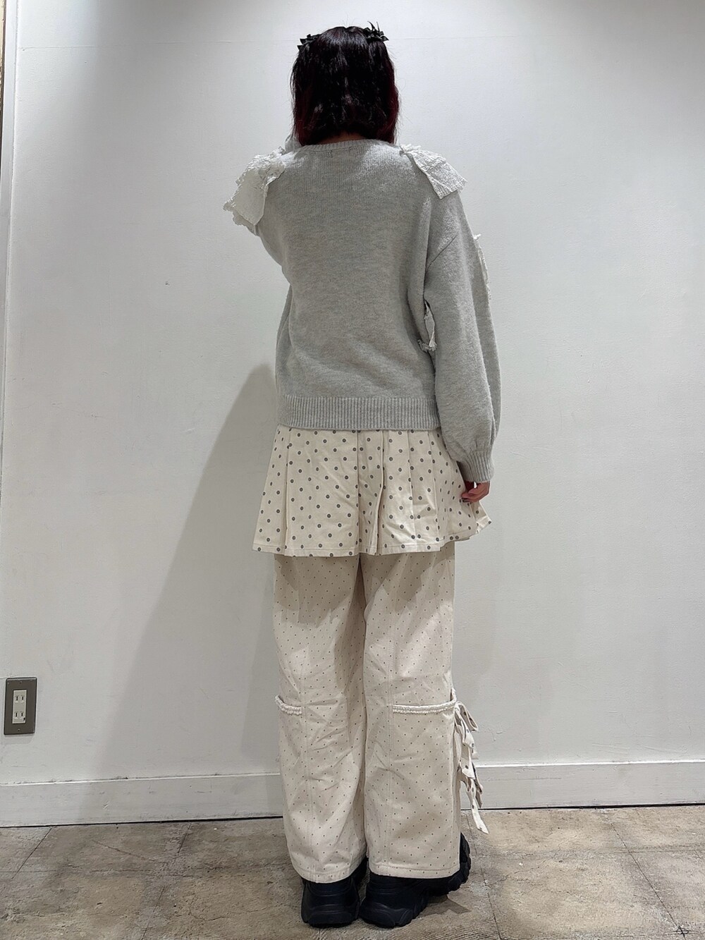 グレー系のニット/セーター、ホワイト系のスカート、ホワイト系のスラックスを着用したレディースの夏コーディネートの2枚目の写真
