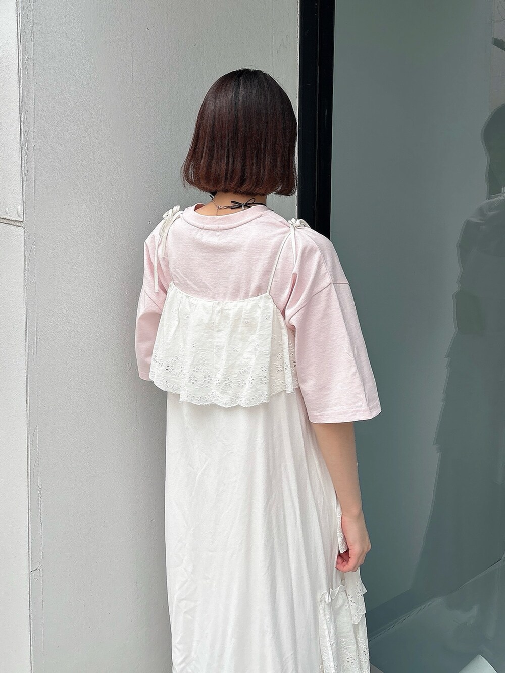 ピンク系のTシャツ/カットソー、ホワイト系のワンピース、ホワイト系のスニーカーを着用したレディースの春コーディネートの4枚目の写真
