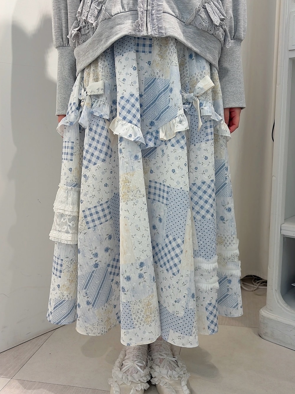 グレー系のパーカー、ブルー系のスカート、ホワイト系のバレエシューズを着用したレディースの冬コーディネートの6枚目の写真