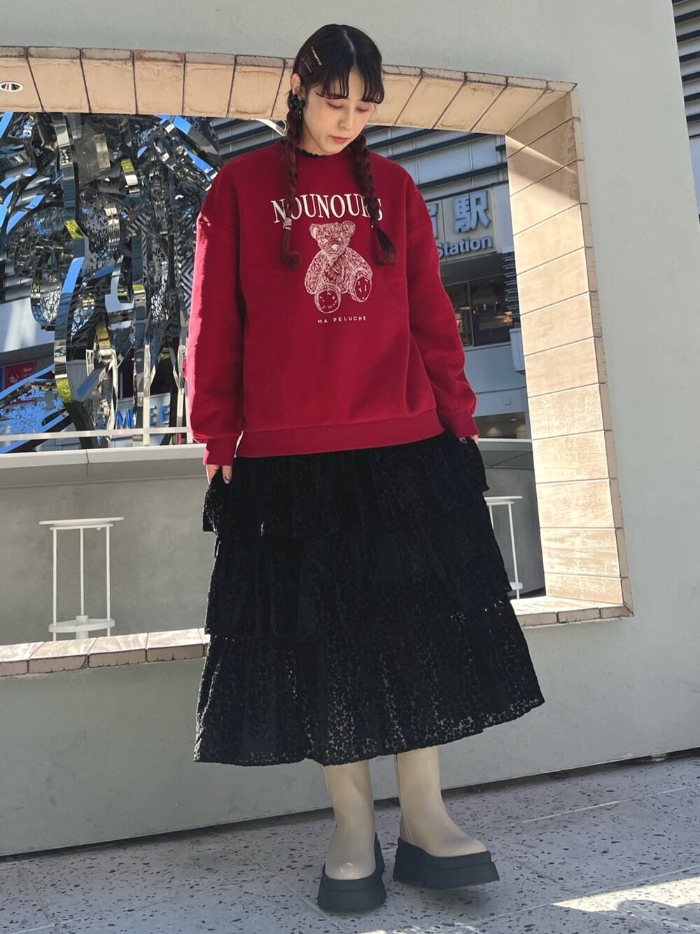 ベージュ系のブーツ、レッド系のスウェット、ブラック系のスカートを着用したレディースの冬コーディネートの3枚目の写真