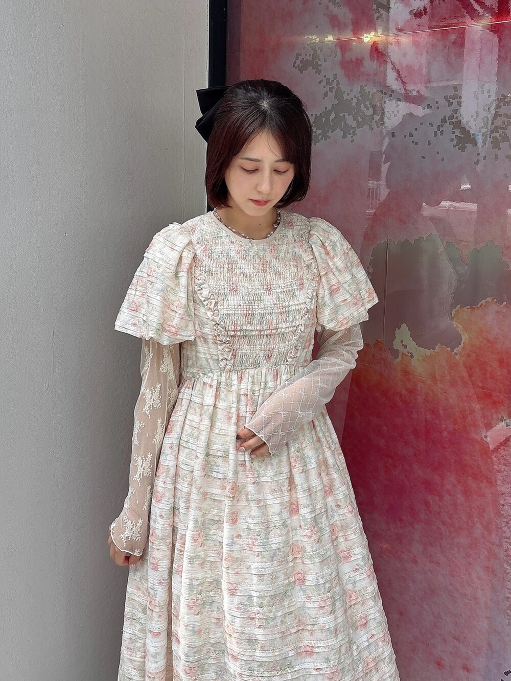 ピンク系のワンピース、ホワイト系のスカート、ホワイト系のスニーカーを着用したレディースの夏コーディネートの3枚目の写真