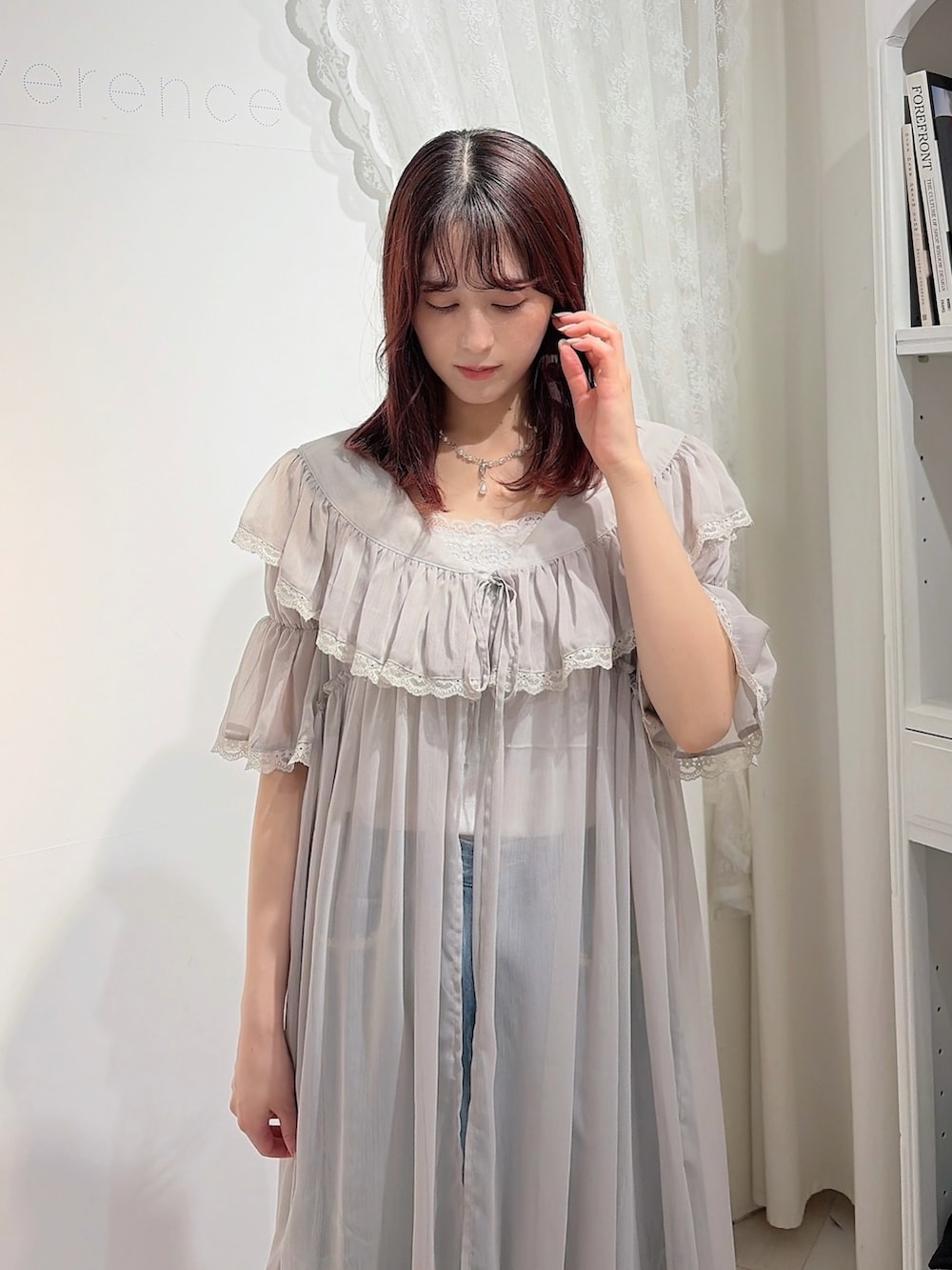 グレー系のワンピース、ホワイト系のキャミソール、ブルー系のデニムパンツを着用したレディースの春コーディネートの3枚目の写真