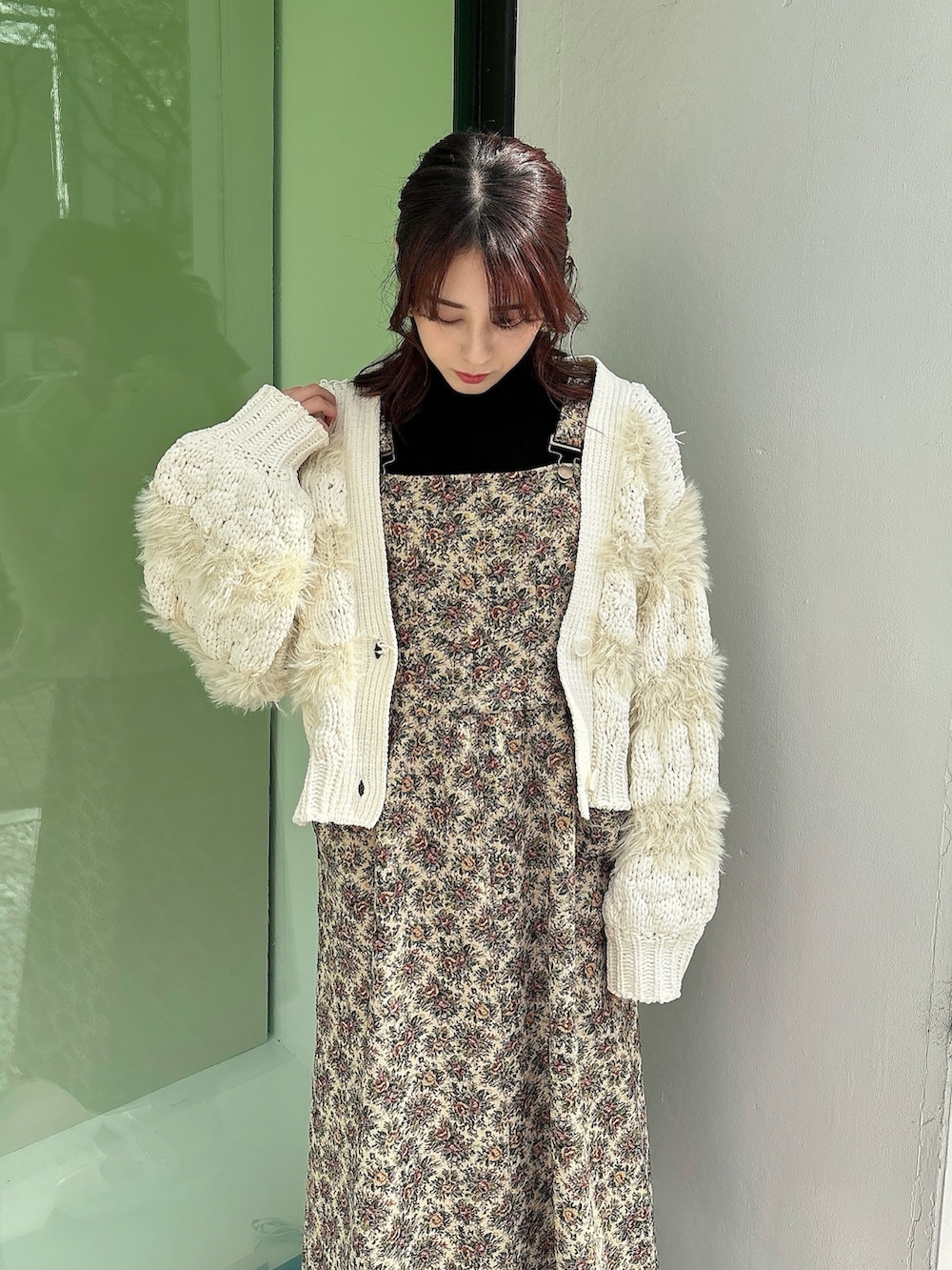 ベージュ系のジャンパースカート、ホワイト系のニット/セーター、ブラック系のニット/セーターを着用したレディースの冬コーディネートの3枚目の写真