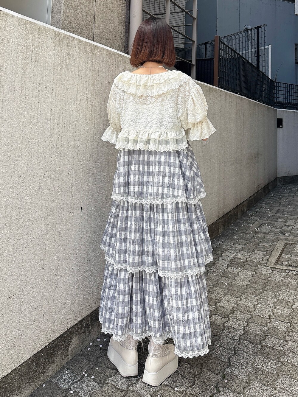 ホワイト系のカーディガン/ボレロ、グレー系のワンピース、ホワイト系のバレエシューズを着用したレディースの春コーディネートの2枚目の写真