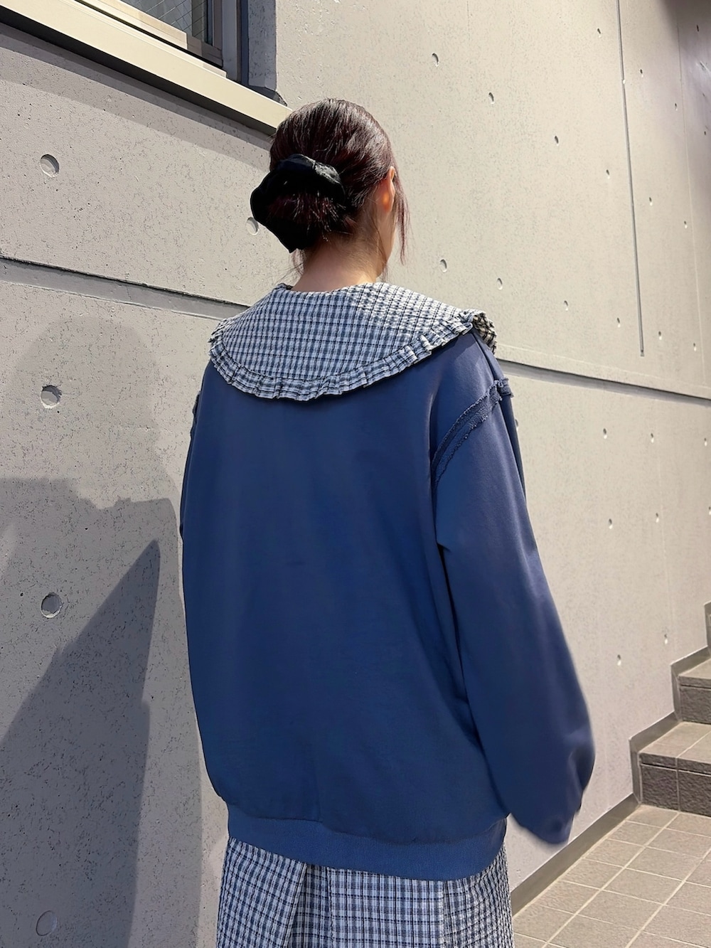 ブルー系のスウェット、ブルー系のワンピース、ブラック系のスニーカーを着用したレディースの冬コーディネートの4枚目の写真