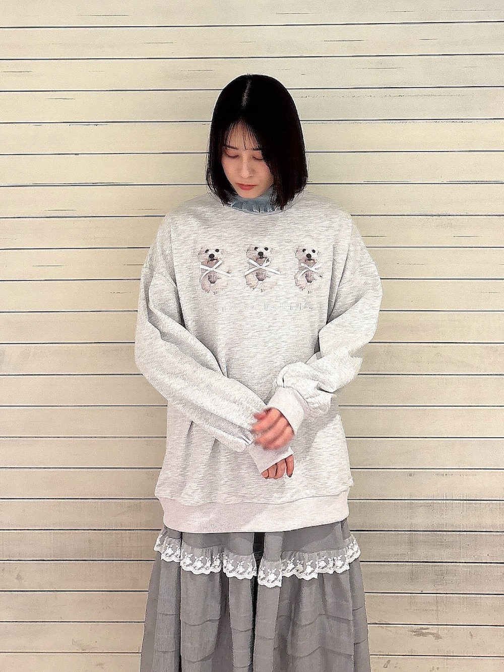 ブルー系のニット/セーター、グレー系のスウェット、グレー系のスカートを着用したレディースの冬コーディネートの2枚目の写真