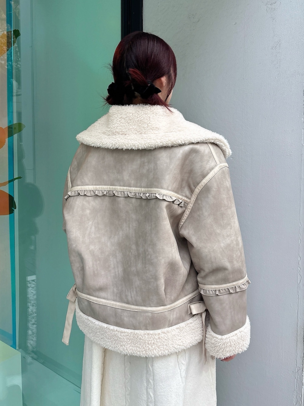 ベージュ系のムートンコート、ホワイト系のワンピース、ブラック系のブーツを着用したレディースの秋コーディネートの4枚目の写真