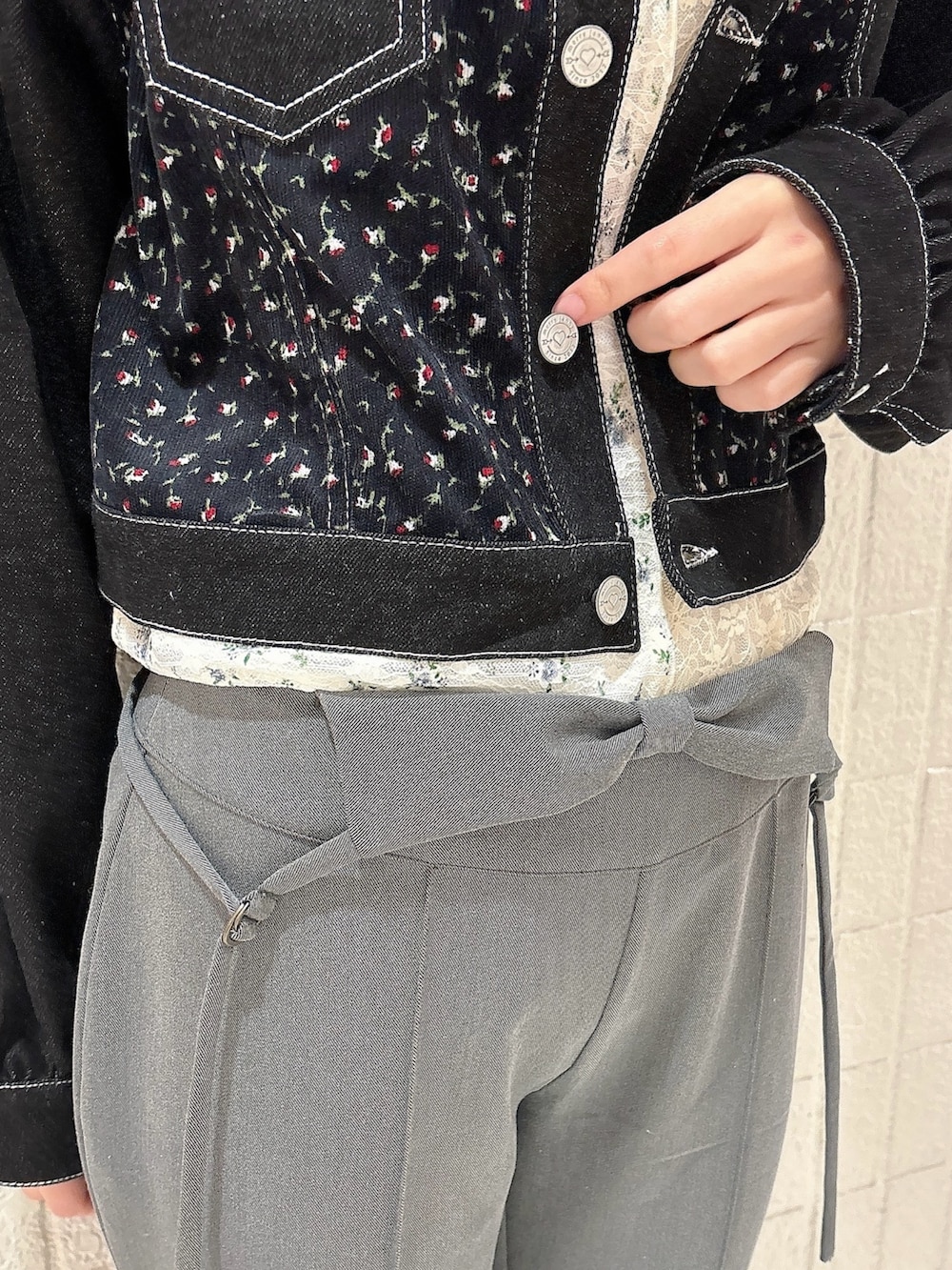 グレー系のスラックス、ブラック系のバレエシューズ、ブラック系のデニムジャケットを着用したレディースの春コーディネートの6枚目の写真