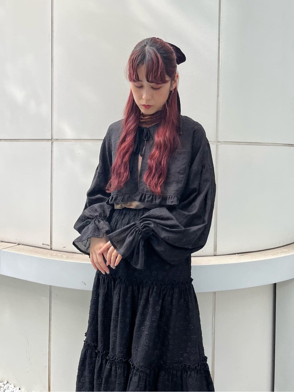 ブラック系のスカート、ブラック系のブーツ、ブラウン系のTシャツ/カットソーを着用したレディースの夏コーディネートの2枚目の写真