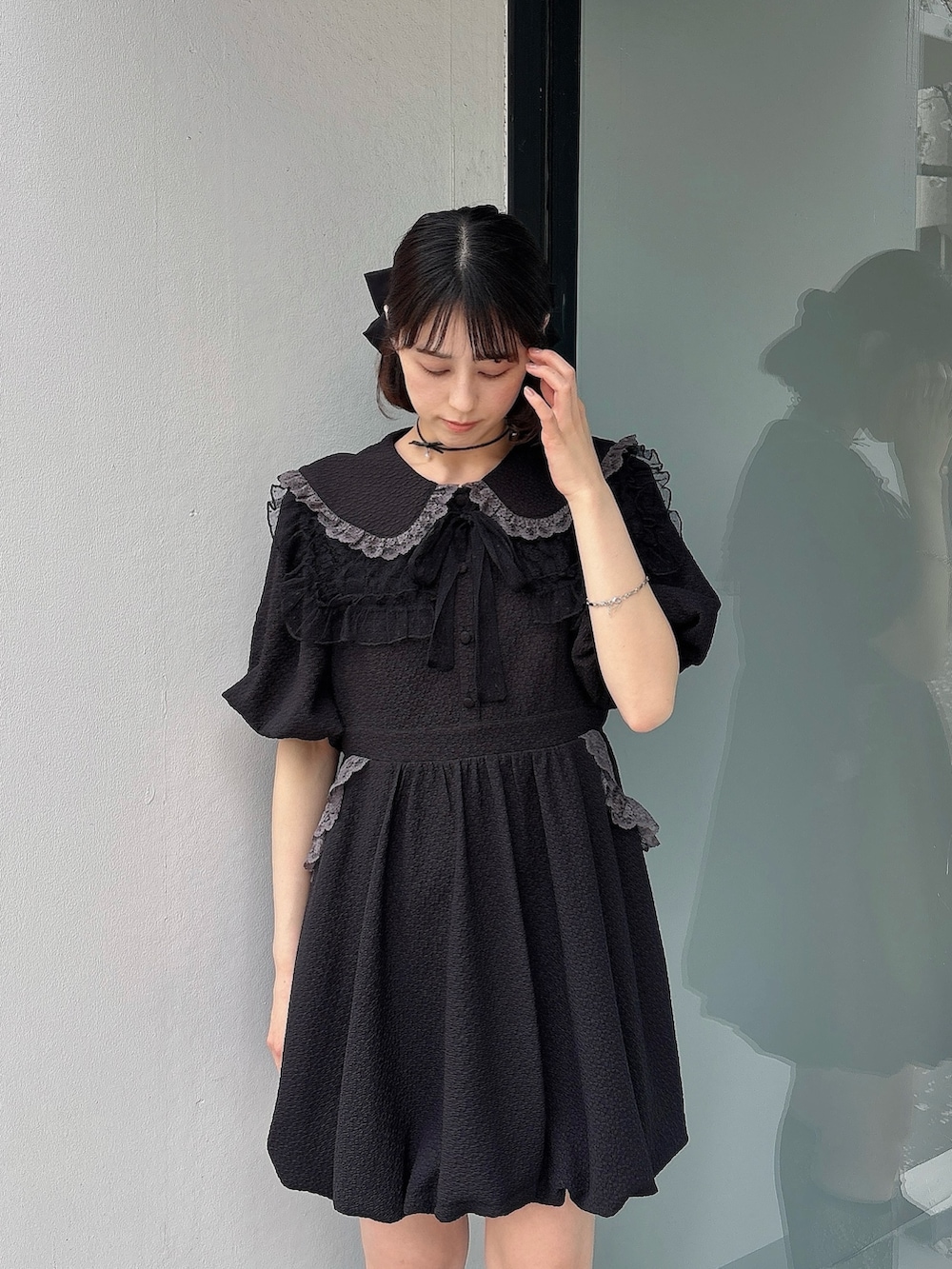 ブラック系のワンピース、ブラック系のスニーカー、ブラック系の付け襟を着用したレディースの春コーディネートの3枚目の写真