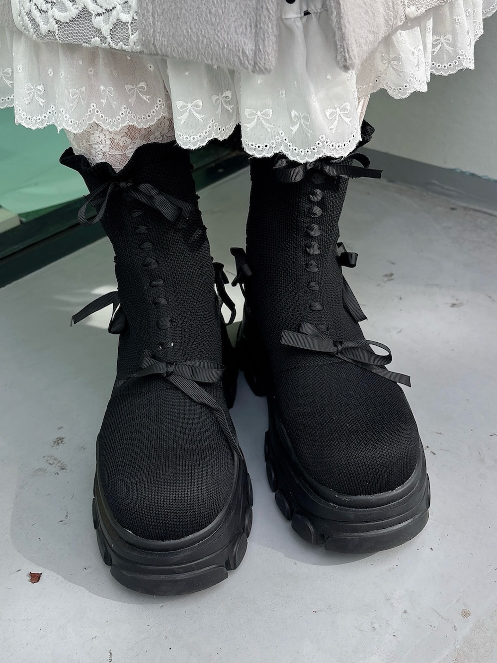 グレー系のチェスターコート、ベージュ系のショルダーバッグ、ホワイト系のワンピースを着用したレディースの秋コーディネートの7枚目の写真