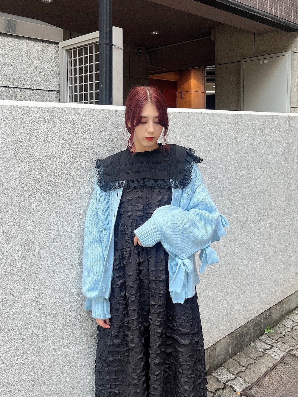 ブラック系のワンピース、ブラック系のブーツ、ブルー系のカーディガン/ボレロを着用したレディースの秋コーディネートの2枚目の写真