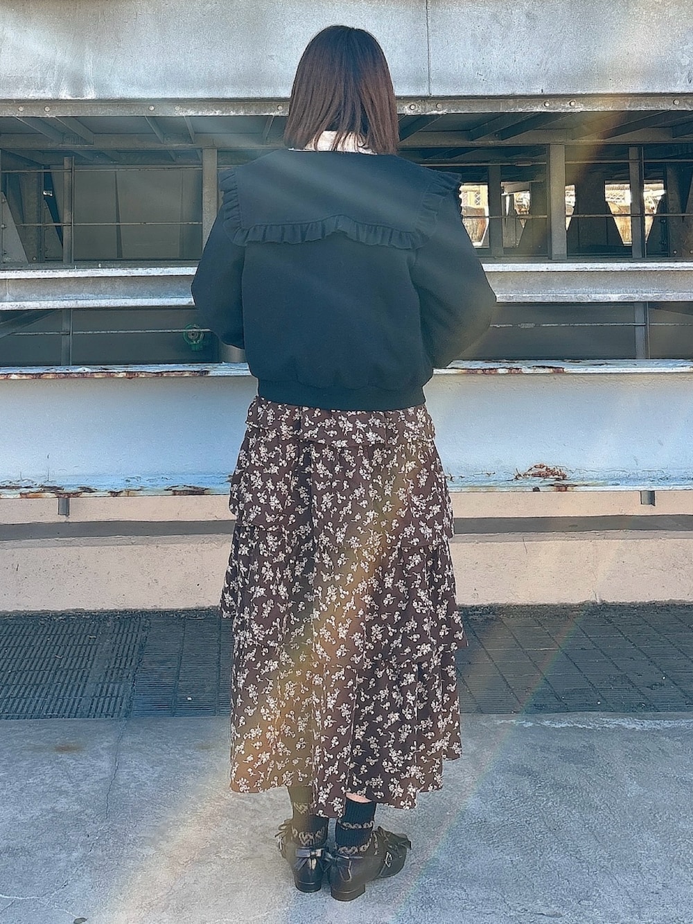 ブラウン系のワンピース、ブラック系のパンプス、ピンク系のカーディガン/ボレロを着用したレディースの冬コーディネートの2枚目の写真