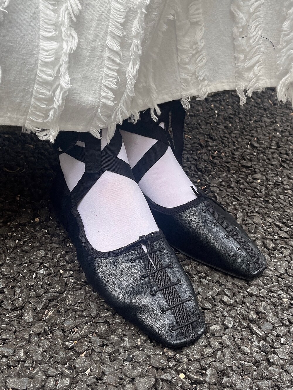 ブラック系のパンプス、ホワイト系のワンピース、ピンク系のシャツ/ブラウスを着用したレディースの春コーディネートの3枚目の写真