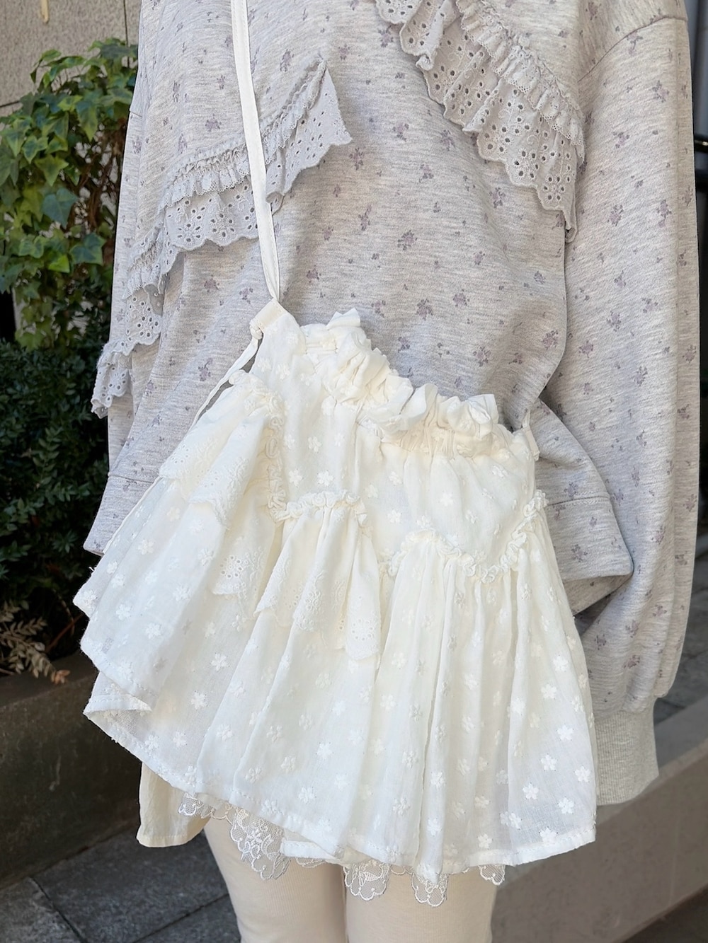 グレー系のスウェット、ホワイト系のショルダーバッグ、ホワイト系のスウェットパンツを着用したレディースの冬コーディネートの7枚目の写真