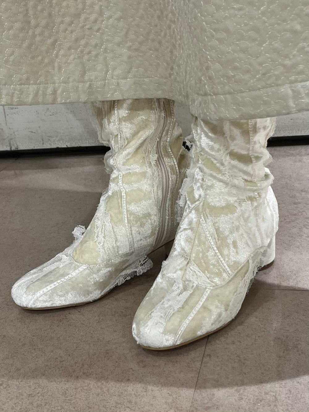 グリーン系のショルダーバッグ、グリーン系のカーディガン/ボレロ、ホワイト系のブーツを着用したレディースの冬コーディネートの3枚目の写真