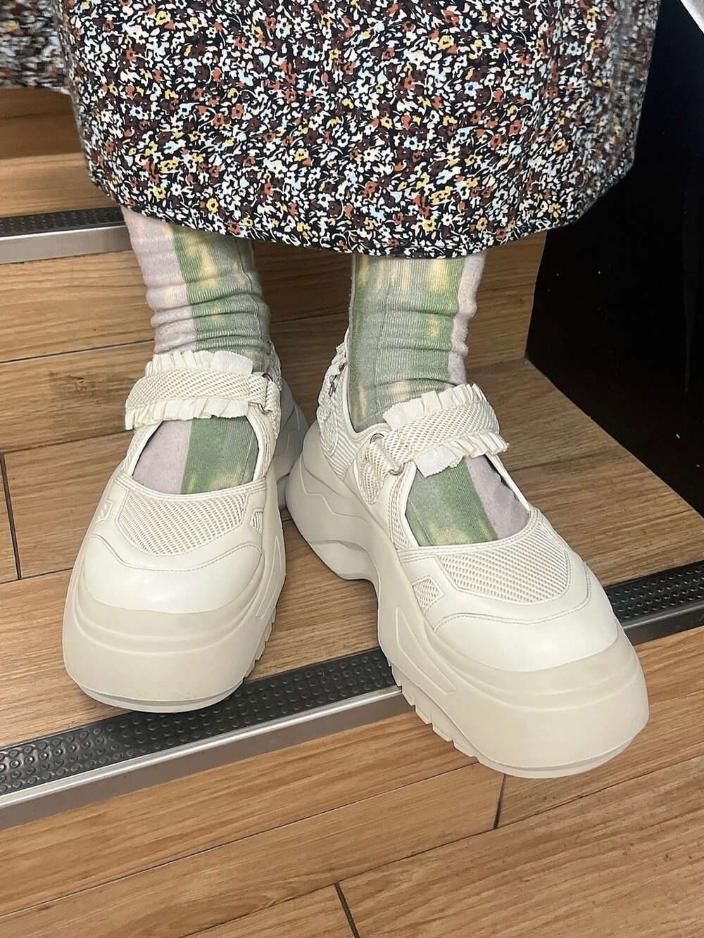 ブラウン系のワンピース、ホワイト系のスニーカー、ブラック系のニット/セーターを着用したレディースの秋コーディネートの3枚目の写真