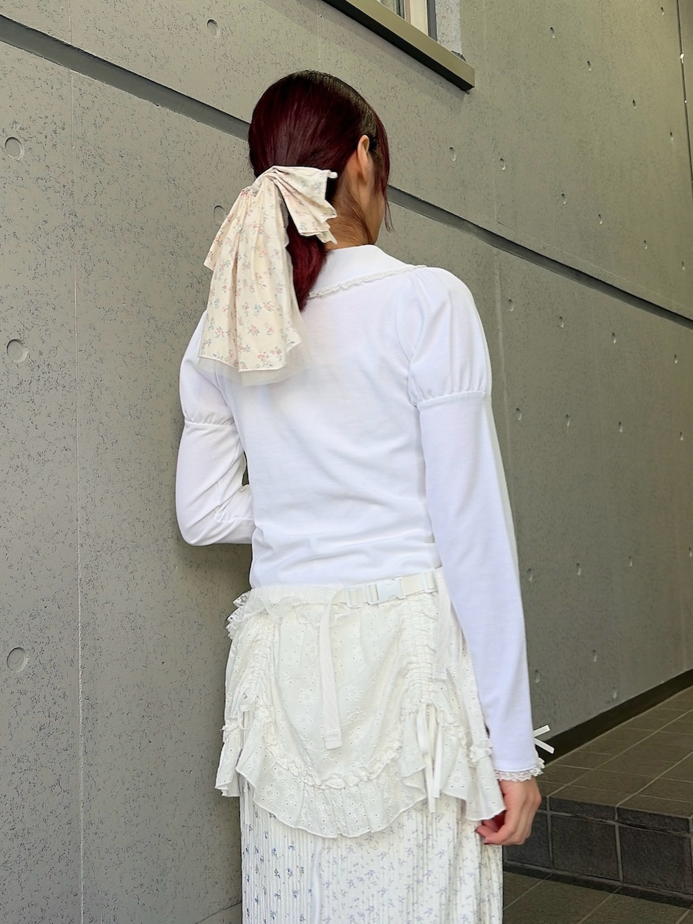 ホワイト系のポロシャツ、ホワイト系のボディバッグ/ウエストポーチ、ホワイト系のスカートを着用したレディースの冬コーディネートの4枚目の写真