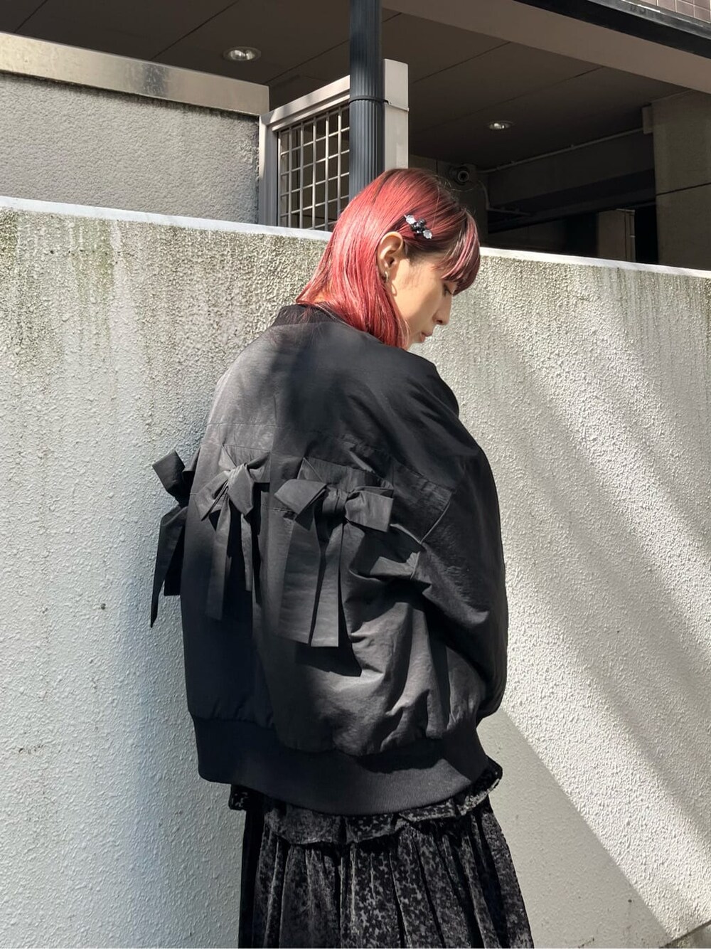ブラック系のニット/セーター、ブラック系のスカート、ブラック系のモカシン/デッキシューズを着用したレディースの秋コーディネートの4枚目の写真