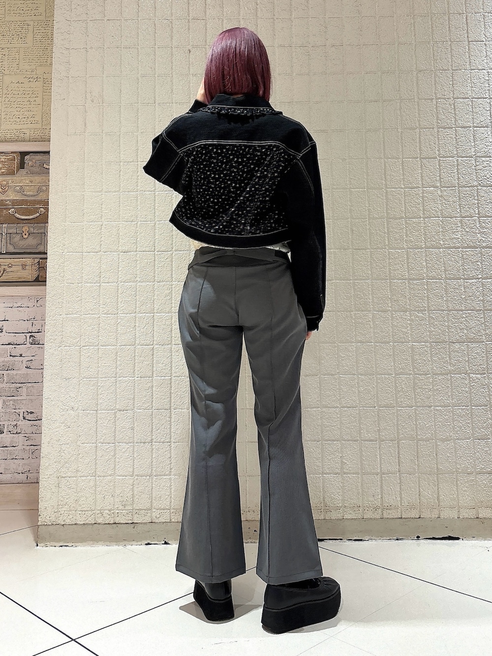 グレー系のスラックス、ブラック系のバレエシューズ、ブラック系のデニムジャケットを着用したレディースの春コーディネートの2枚目の写真