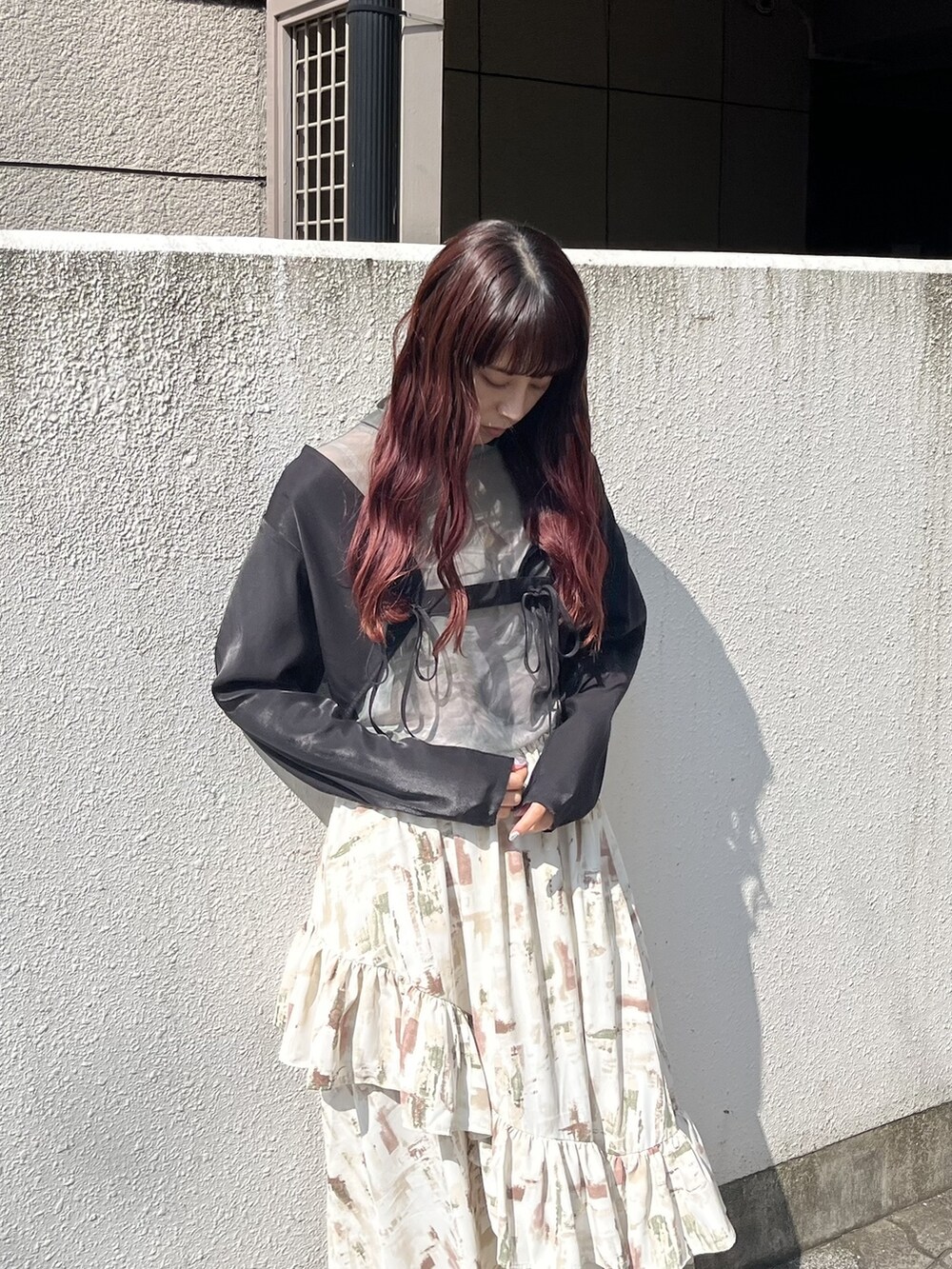 ブラウン系のスカート、ブラック系のパンプス、グリーン系のTシャツ/カットソーを着用したレディースの春コーディネートの2枚目の写真