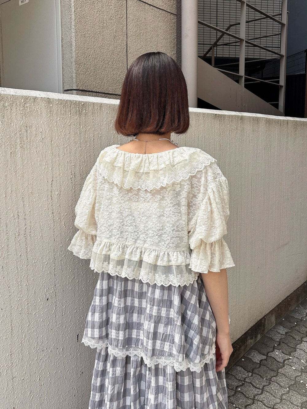 ホワイト系のカーディガン/ボレロ、グレー系のワンピース、ホワイト系のバレエシューズを着用したレディースの春コーディネートの4枚目の写真