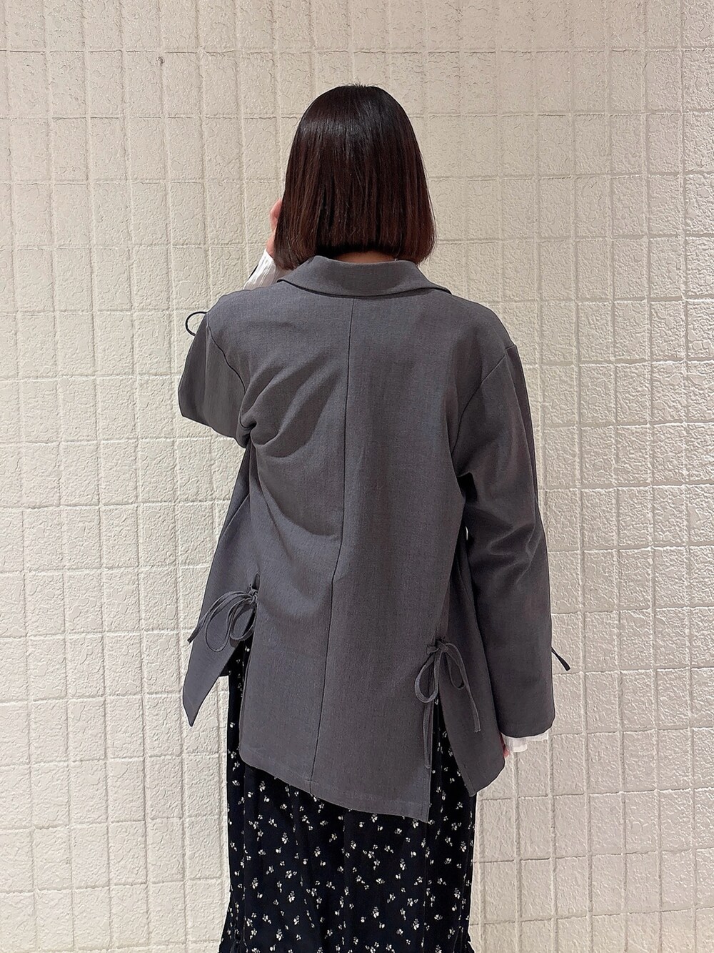 グレー系のテーラードジャケット、ブラック系のワンピースを着用したレディースの冬コーディネートの4枚目の写真