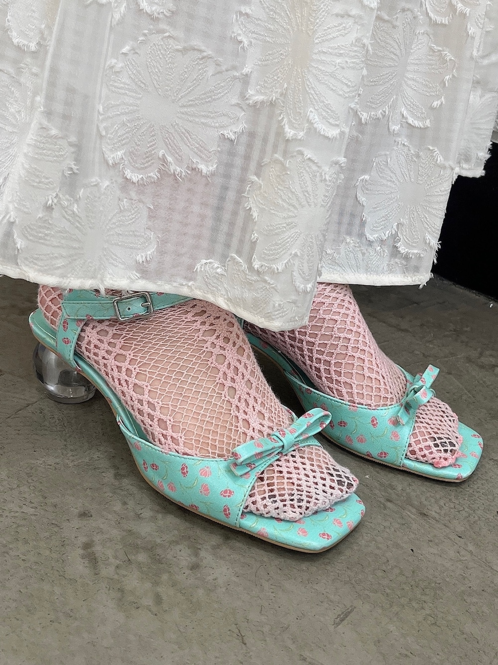 ブルー系のTシャツ/カットソー、グリーン系のパンプス、ホワイト系のスカートを着用したレディースの春コーディネートの4枚目の写真