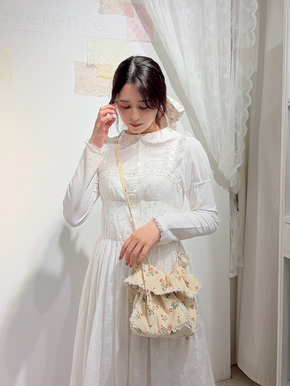 ホワイト系のポロシャツ、ホワイト系のワンピース、ホワイト系のショルダーバッグを着用したレディースの冬コーディネートの3枚目の写真