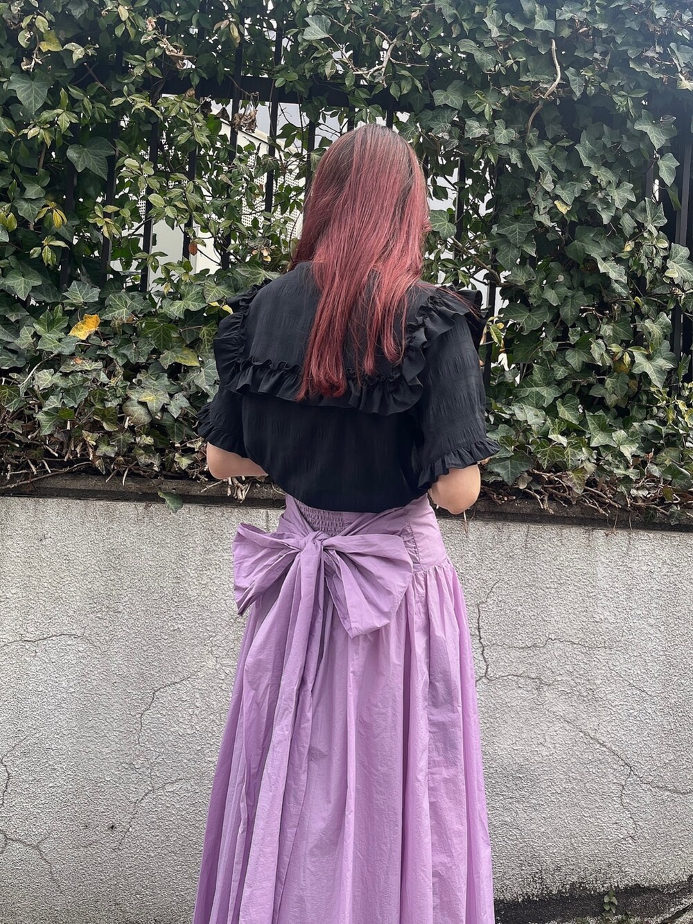 ブラック系のシャツ/ブラウス、ピンク系のスカート、ブラック系のサンダルを着用したレディースの春コーディネートの3枚目の写真