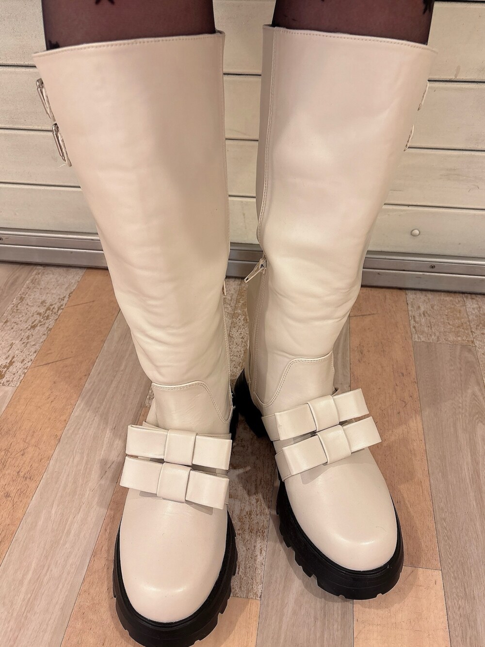 グレー系のニット/セーター、ブラウン系のノーカラーコート、ブルー系のワンピースを着用したレディースの冬コーディネートの9枚目の写真