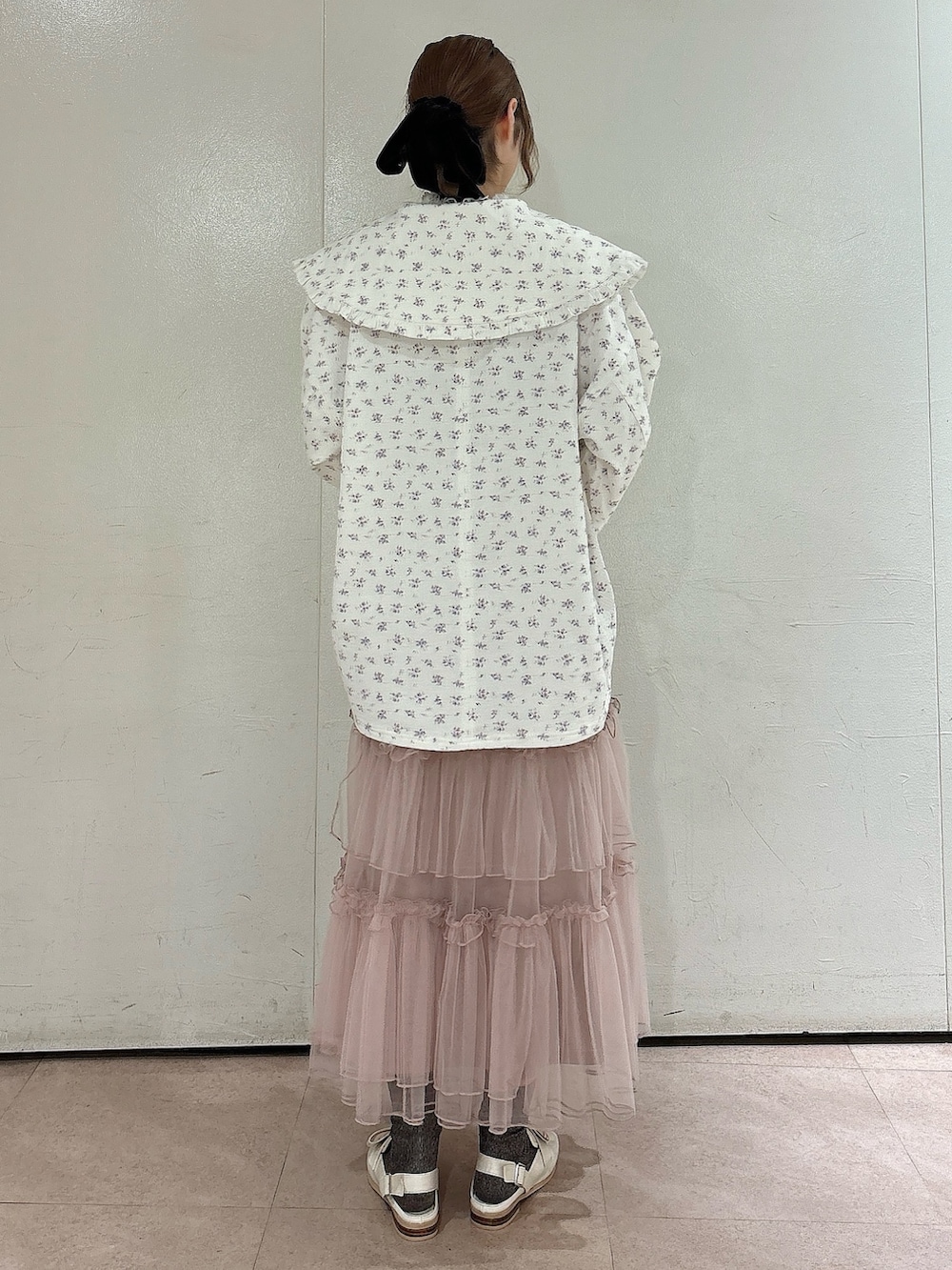 ホワイト系のデニムジャケット、ピンク系のスカート、ホワイト系のローファーを着用したレディースの秋コーディネートの2枚目の写真