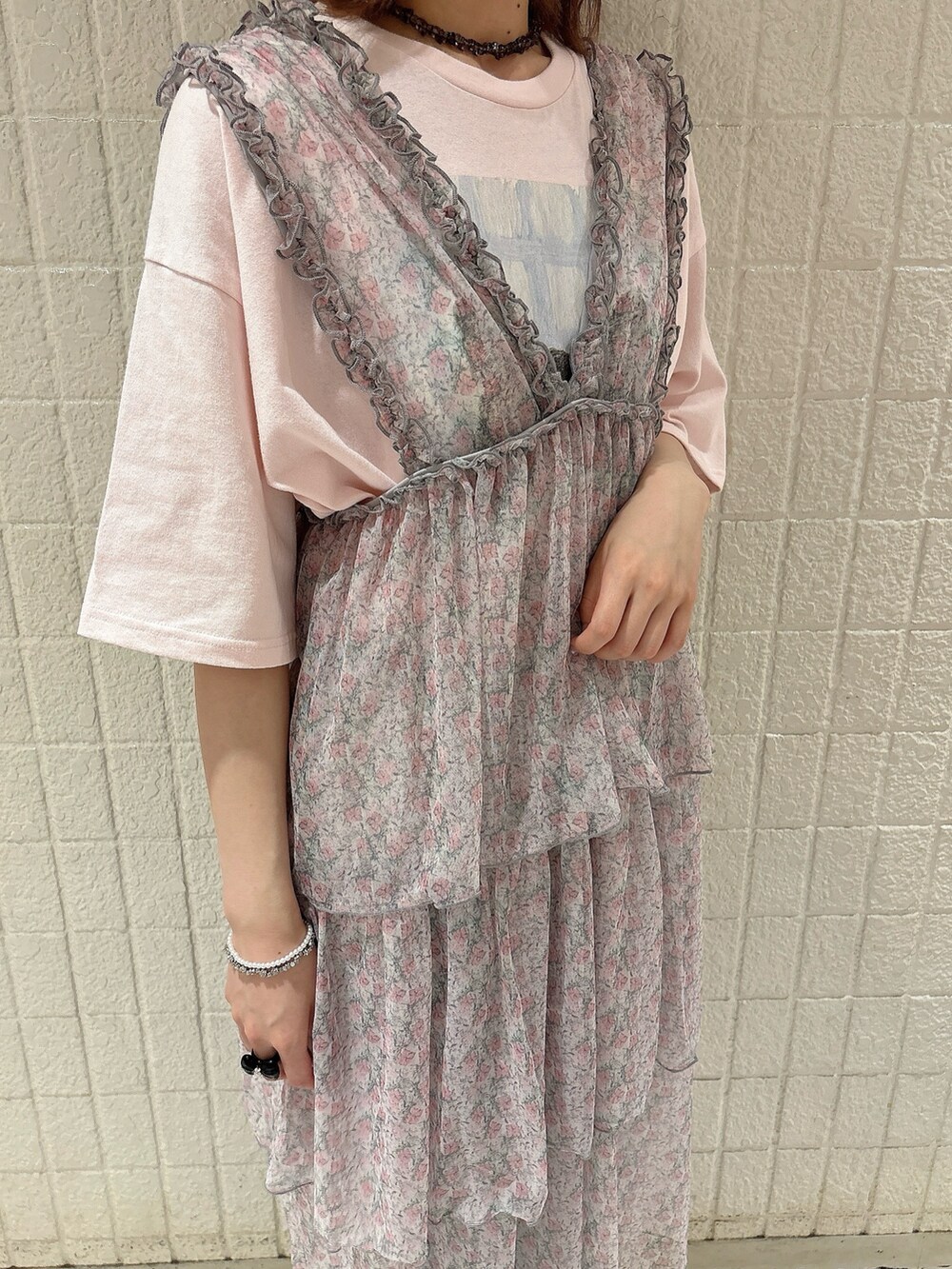 ピンク系のワンピース、ブルー系のデニムパンツ、ブルー系のサンダルを着用したレディースの夏コーディネートの5枚目の写真