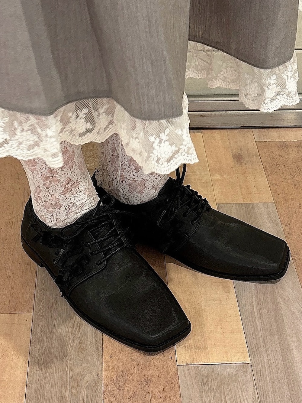 ブラック系のニット/セーター、グレー系のスカート、ブラック系のローファーを着用したレディースの秋コーディネートの7枚目の写真